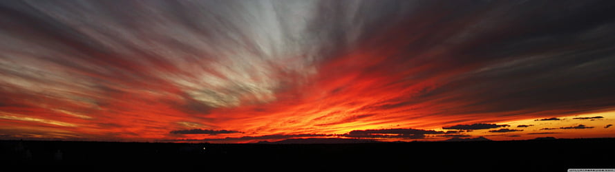 Vivid Crimson Sunset Sky with Dramatic Streaked Clouds Over Dark Horizon HD wallpaper