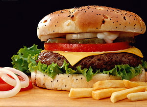 Classic Cheeseburger with Sesame Bun, Fresh Lettuce, Tomato, Pickles, and French Fries on a Wooden Board HD wallpaper