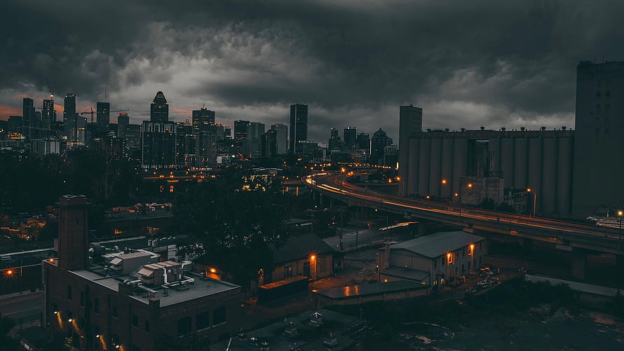 Moody City Skyline at Dusk with Highway Traffic and Industrial Buildings HD wallpaper