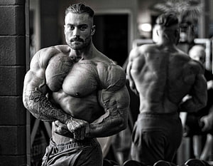 Black And White Photo Of Muscular Bodybuilder Flexing In Gym HD wallpaper