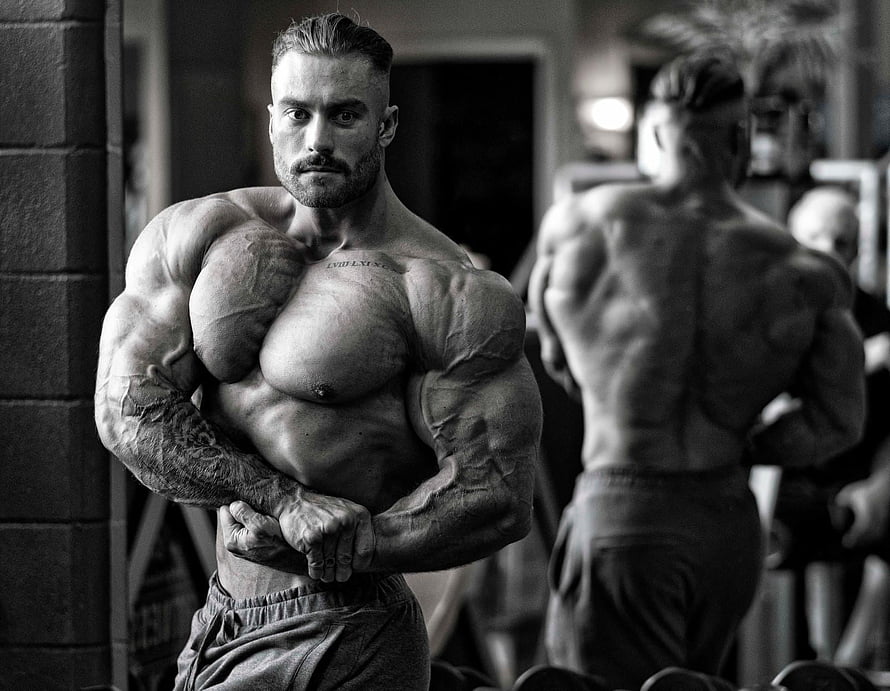 Black And White Photo Of Muscular Bodybuilder Flexing In Gym HD wallpaper