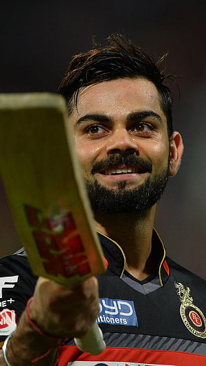 Virat Kohli holding a cricket bat while wearing a Royal Challengers Bangalore jersey HD phone wallpaper