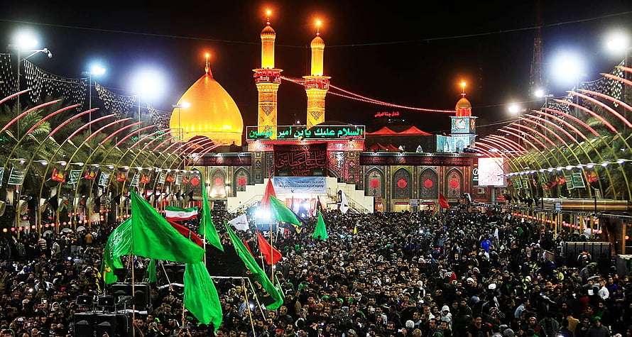Night view of Imam Reza shrine in Mashhad with massive crowd waving green flags during religious procession HD wallpaper