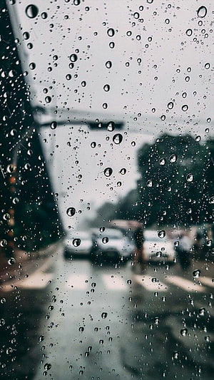 Moody Rainy Day View Through a Wet Window with Blurred Street Scene HD phone wallpaper