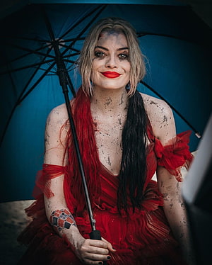 Harley Quinn in Red Dress Holding Blue Umbrella with Mud Splatters and Joker Tattoo HD phone wallpaper