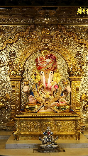 Ornate Golden Ganesha Statue in Temple Shrine with Intricate Carvings HD phone wallpaper