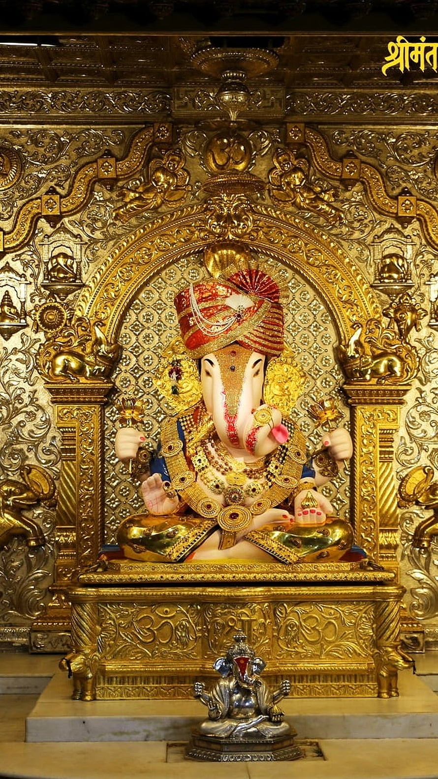 Ornate Golden Ganesha Statue in Temple Shrine with Intricate Carvings HD phone wallpaper