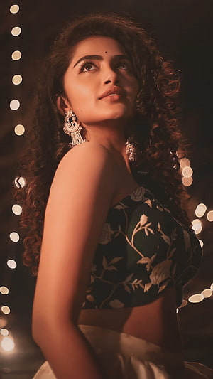 Anupama Parameswaran in a floral blouse with traditional jhumka earrings and bokeh lights HD phone wallpaper