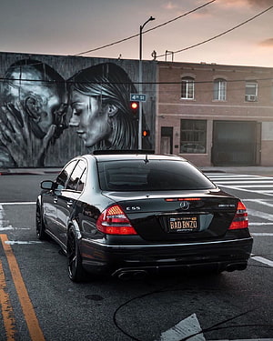 Black Mercedes-Benz E55 AMG Wagon on Urban Street with Mural HD phone wallpaper