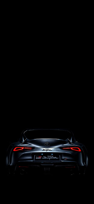 Rear View of Black Toyota GR Supra A90 with Glowing Red Taillights Against Dark Background HD phone wallpaper