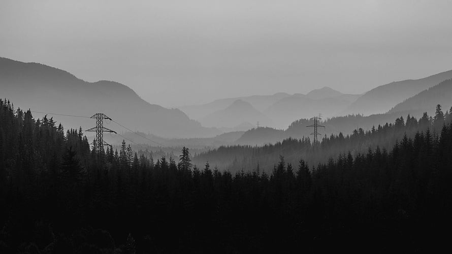 Monochrome Misty Mountain Valley With Silhouetted Forest And Power Lines HD wallpaper