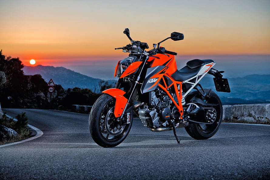 Orange KTM 200 Duke Motorcycle Parked on Mountain Road at Sunset HD wallpaper