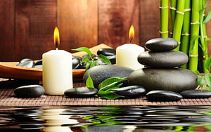 Serene Spa Still Life With Stacked Black Stones, Lit Candles, Bamboo, and Water Reflection HD wallpaper
