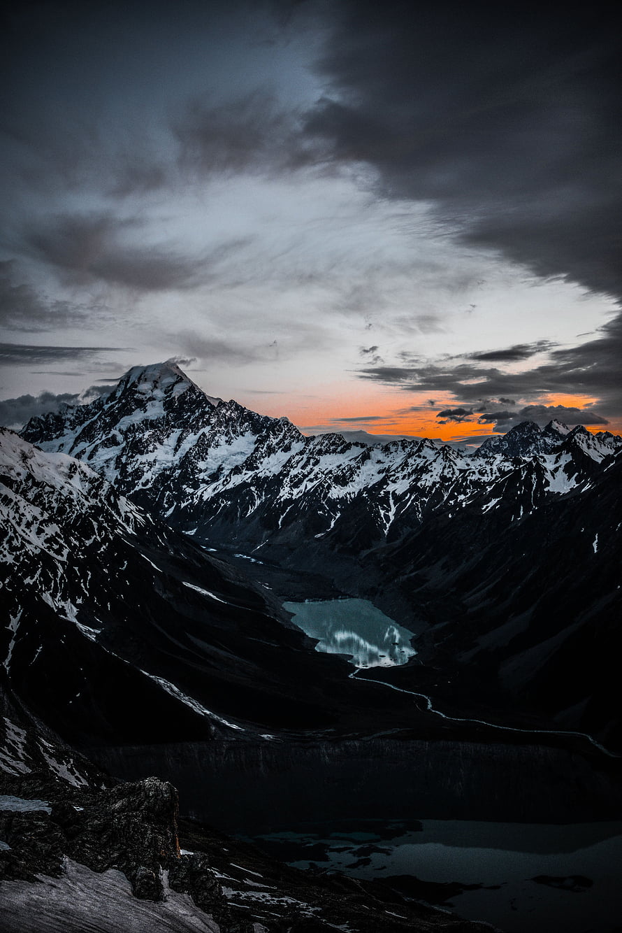 Dramatic Alpine Valley with Glacial Lake at Sunset Under Stormy Skies HD phone wallpaper