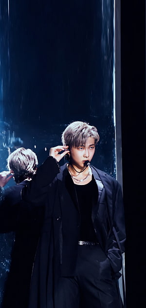 RM from BTS adjusting in-ear monitor on stage in black suit with silver hair HD phone wallpaper