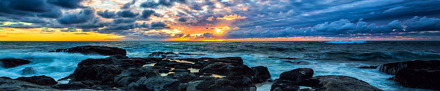Dramatic Ocean Sunset Over Rocky Shoreline with Turbulent Waves and Cloudy Sky HD wallpaper