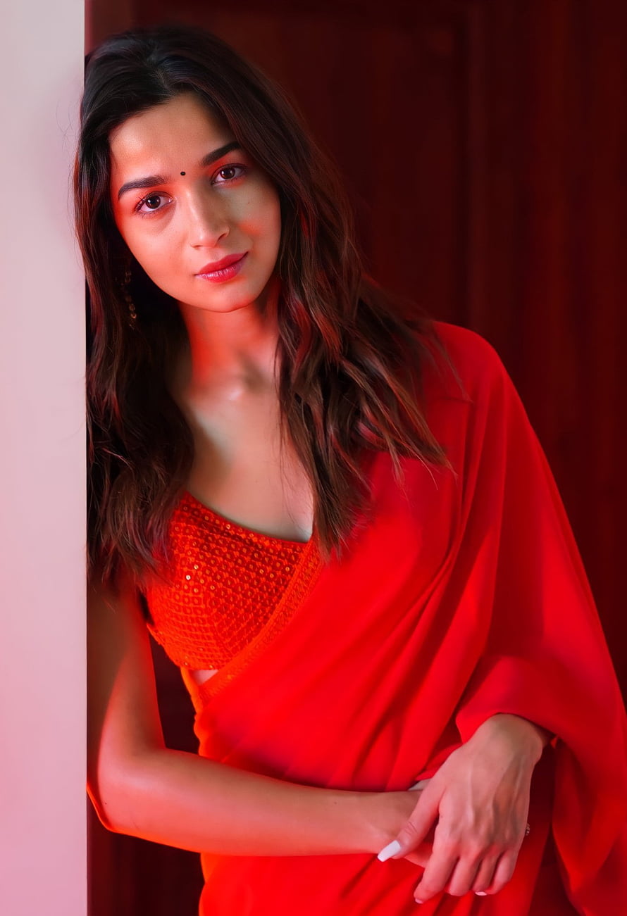 Alia Bhatt in a stunning red saree with a sequined blouse, posing elegantly against a warm-toned background HD phone wallpaper