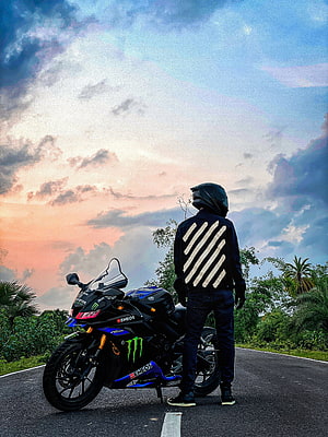 Yamaha R15 V3 sport bike parked on a tropical road at sunset with rider in helmet HD phone wallpaper