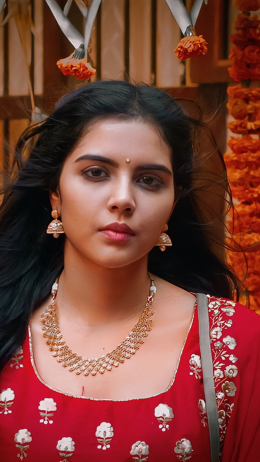 Portrait of a woman in a red embroidered dress with traditional gold jewelry and marigold flowers, Kalyani Priyadarshini, malayalam actress HD phone wallpaper