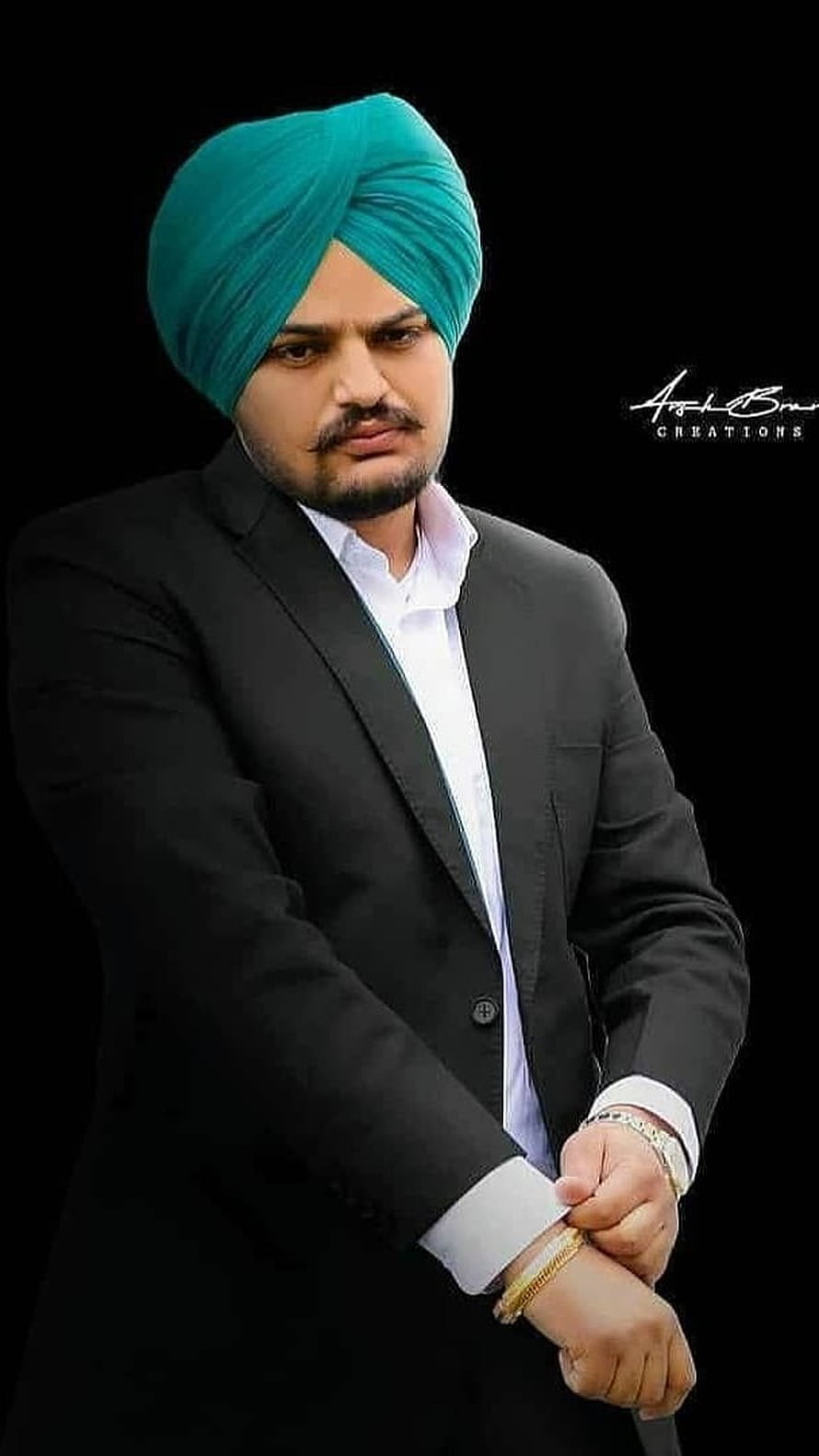Portrait of Diljit Dosanjh in a black suit and teal turban adjusting his cufflinks HD phone wallpaper