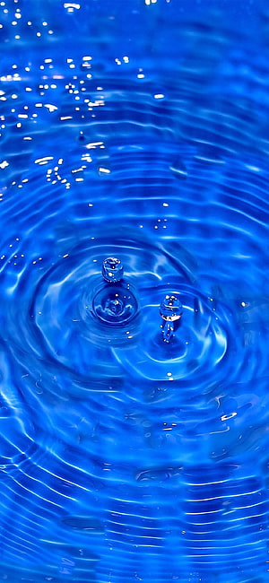 Vibrant Blue Water Ripples with Droplets and Light Reflections HD phone wallpaper