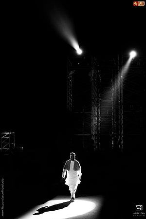 Ilayaraja Walking Through a Dramatic Spotlight in Black and White HD phone wallpaper