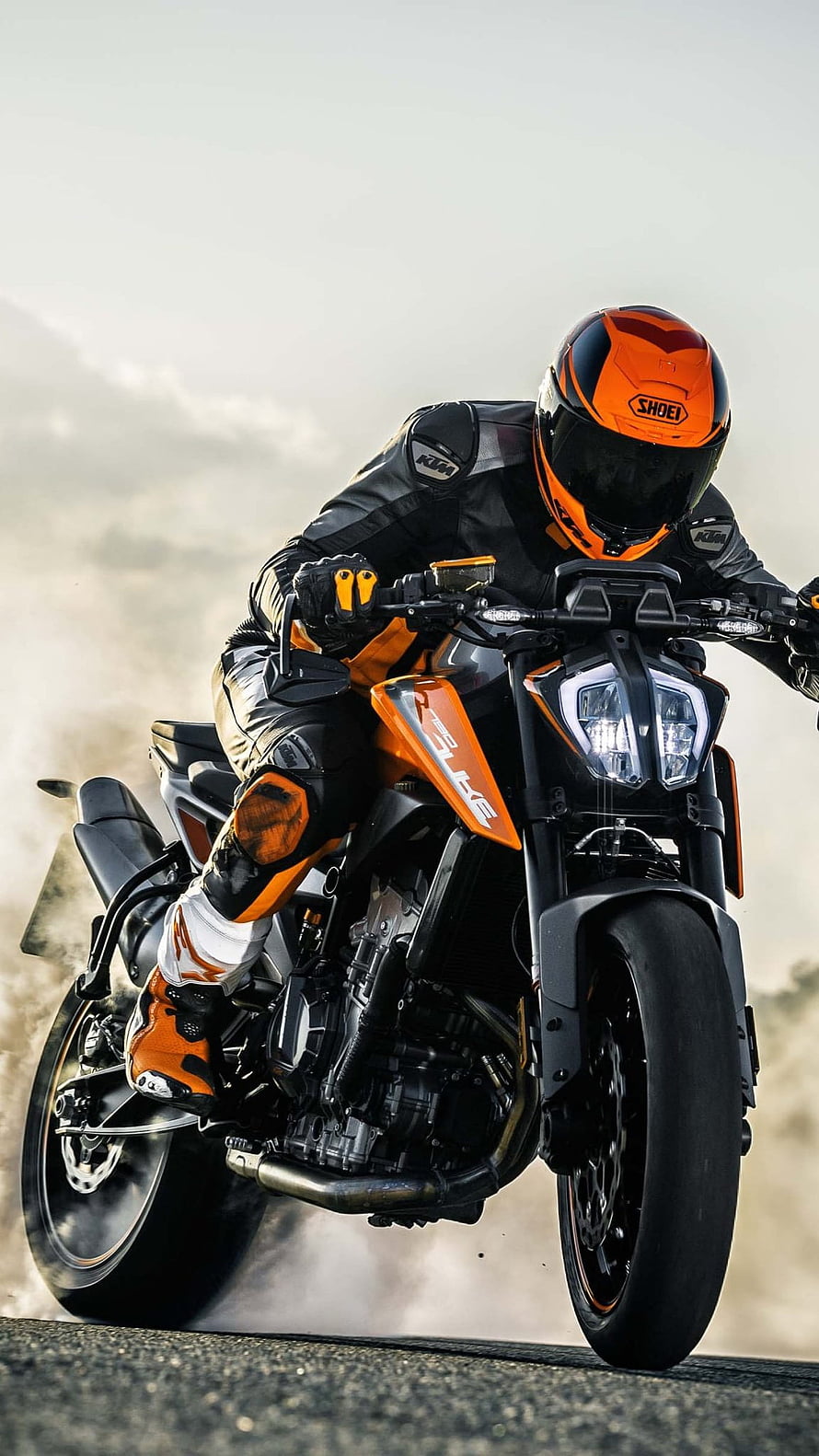 KTM Duke motorcycle rider in full gear performing a wheelie on asphalt road HD phone wallpaper