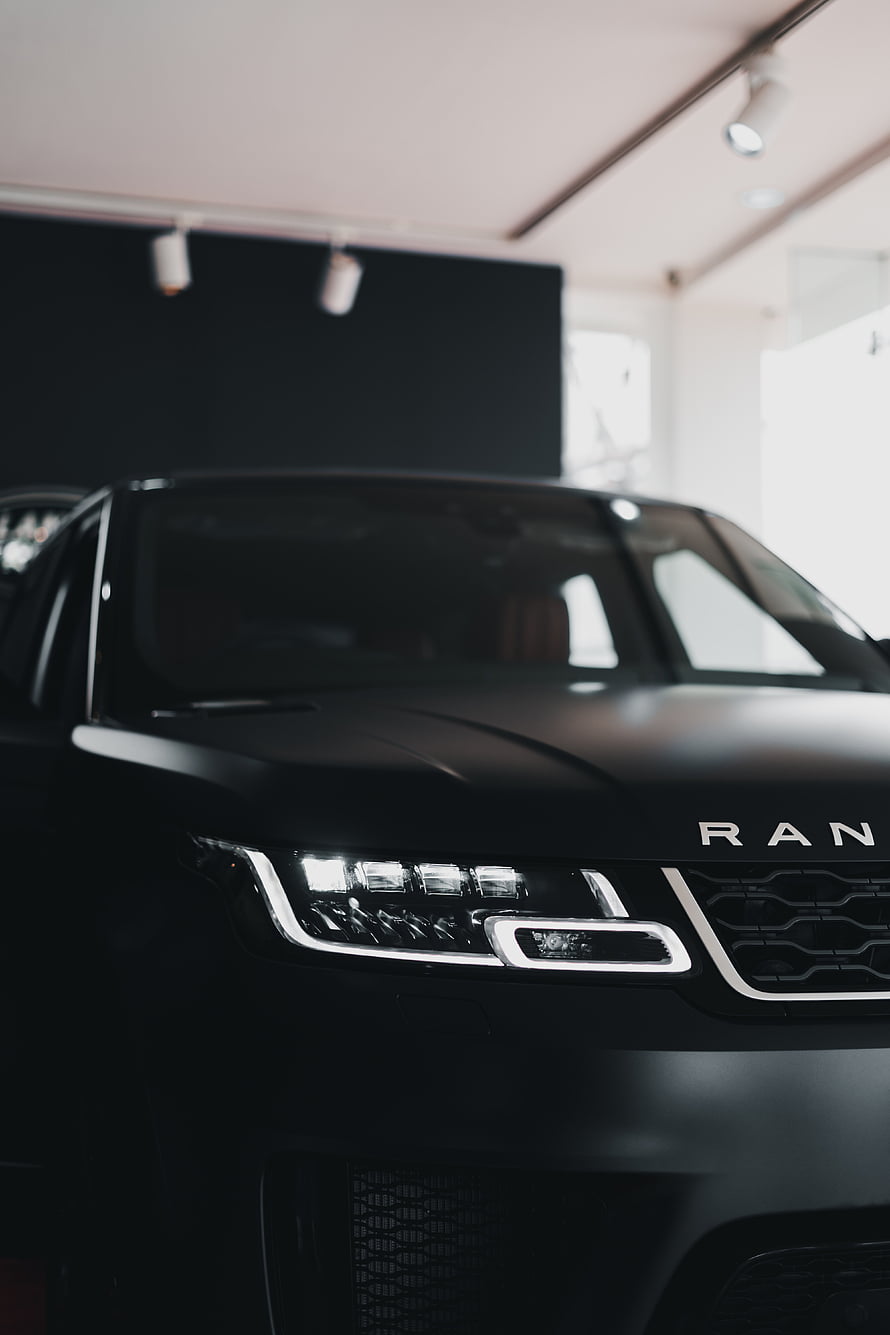 Matte Black Range Rover Front Fascia with LED Headlights in a Modern Showroom Setting HD phone wallpaper