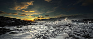 Dramatic Ocean Sunset with Crashing Waves and Rocky Coastline HD wallpaper