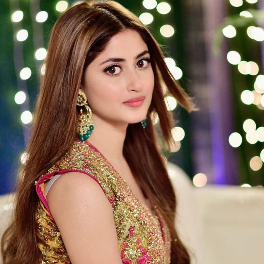 Sara Ali Khan in a glamorous gold and pink embroidered outfit with festive bokeh lights background HD phone wallpaper