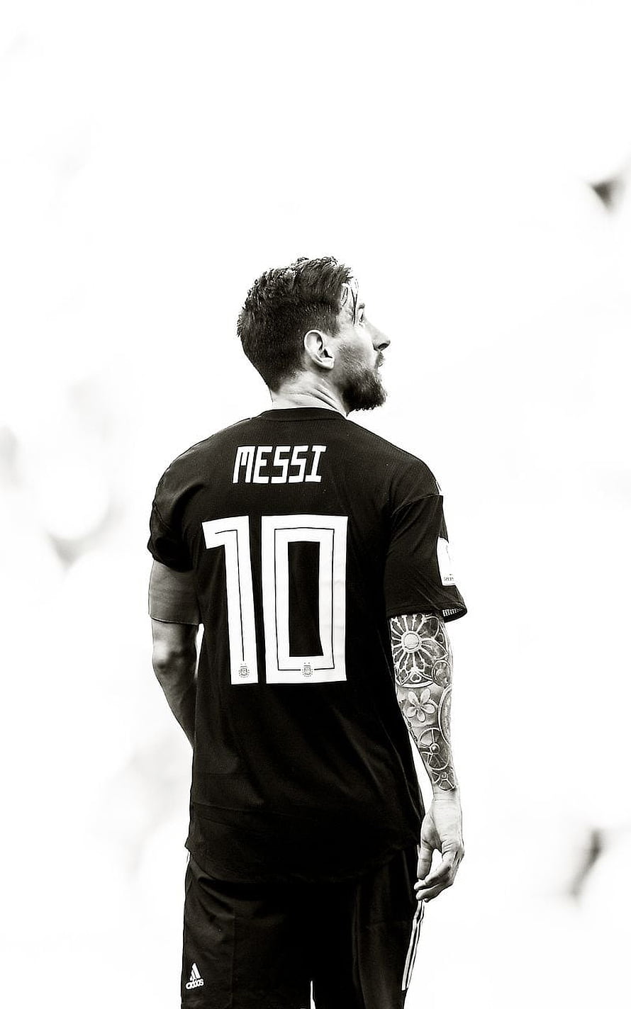 Lionel Messi in Black Away Kit Looking Up in Monochrome Portrait HD phone wallpaper
