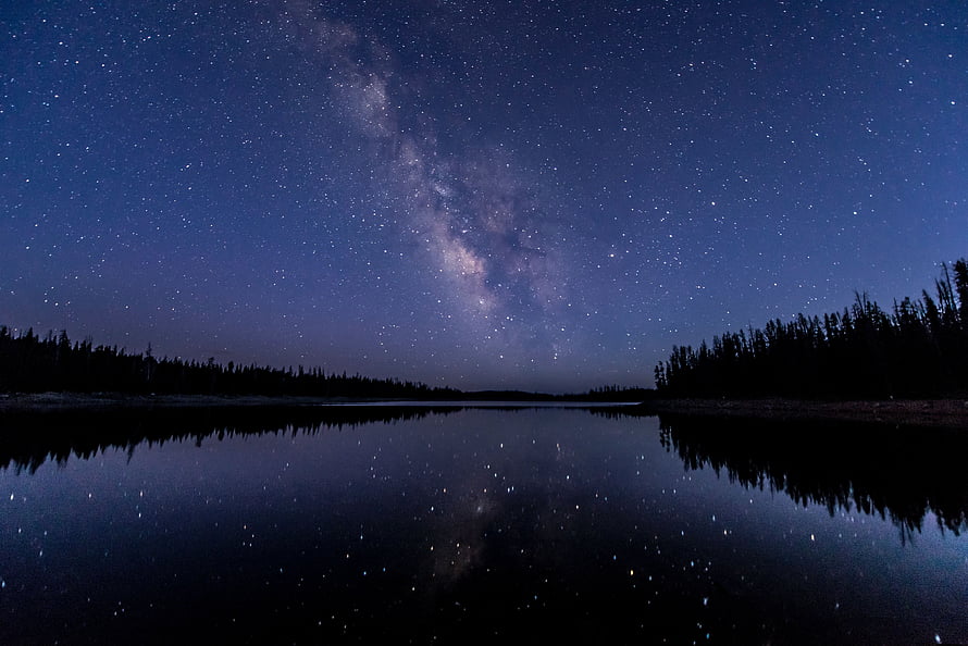 Milky Way Galaxy Reflected in Calm Lake Water with Forest Silhouette HD wallpaper