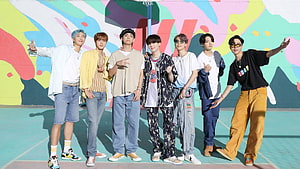 NCT 127 members posing in colorful streetwear on a vibrant outdoor basketball court HD wallpaper