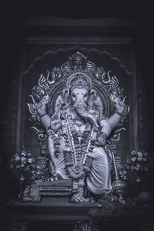 Majestic Black and White Statue of Lord Ganesha Adorned with Floral Garlands HD phone wallpaper