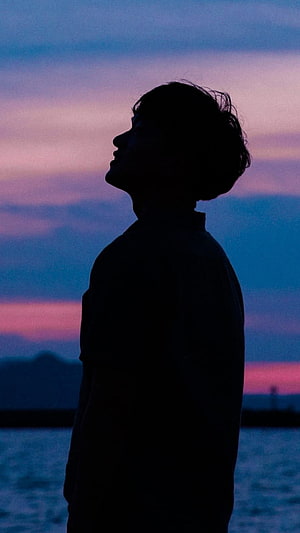 Silhouette of a man looking up at a vibrant purple and blue sunset sky over the ocean, boy, silhouette, sunset, sky PC and Mac, Boy Pic HD phone wallpaper
