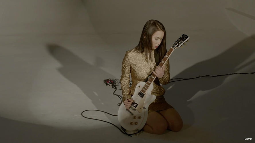 Mitski Playing White Electric Guitar in Gold Sequined Outfit HD wallpaper
