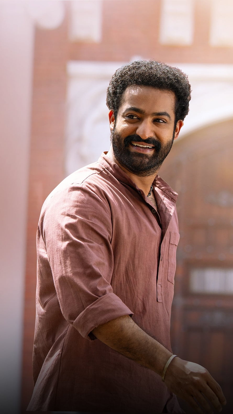 Jr NTR in RRR Bheem Character Portrait with Warm Smile and Rust Shirt HD phone wallpaper
