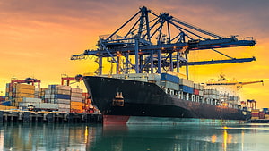 Container Ship Docked at Port Terminal During Golden Sunset HD wallpaper