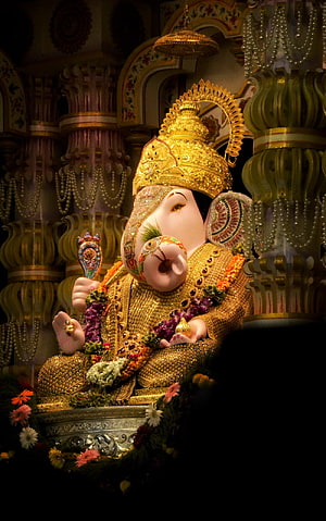 Golden Ganesha Idol Adorned with Jewels and Flowers in Temple HD phone wallpaper