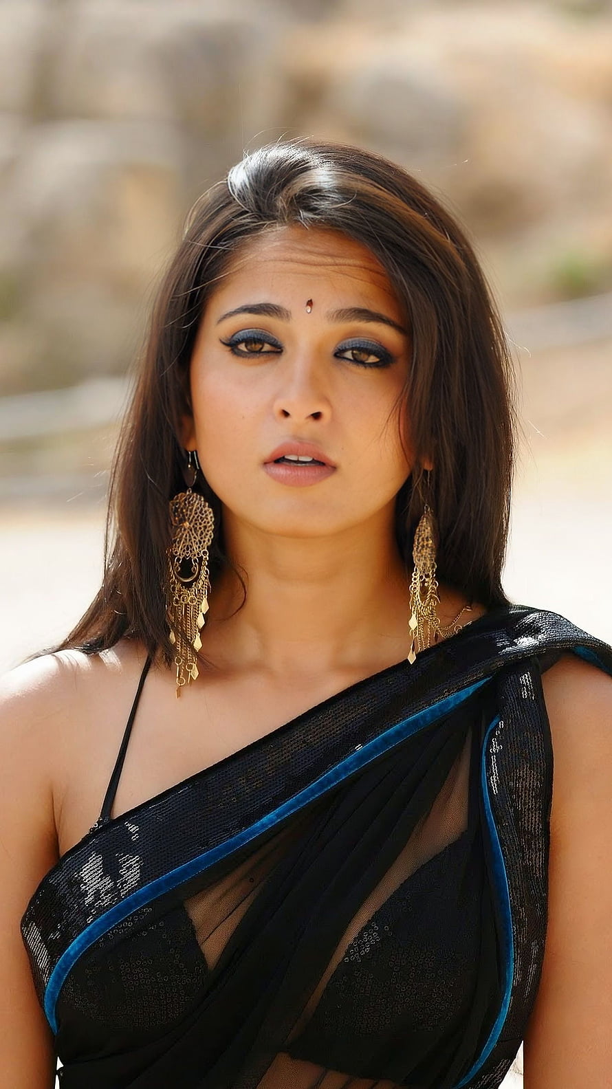 Anushka Shetty in a black saree with blue border and gold earrings HD phone wallpaper