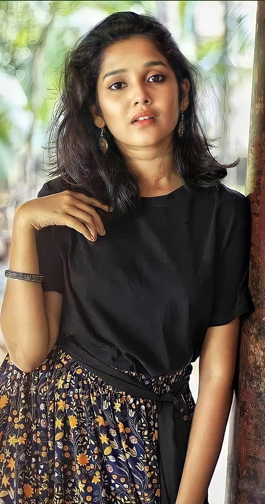 Anikha Surendran in Black Top and Floral Skirt Leaning Against Tree HD phone wallpaper