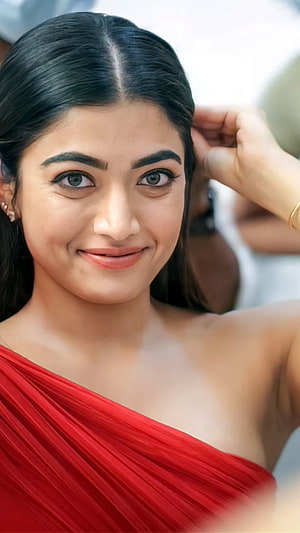 Rashmika Mandanna in a vibrant red saree with a warm smile and elegant pose HD phone wallpaper