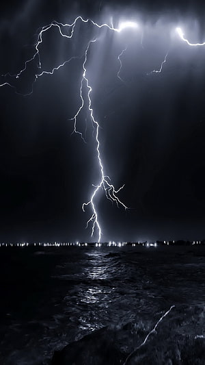 Dramatic Night Lightning Strike Over Dark Ocean With Distant City Lights HD phone wallpaper