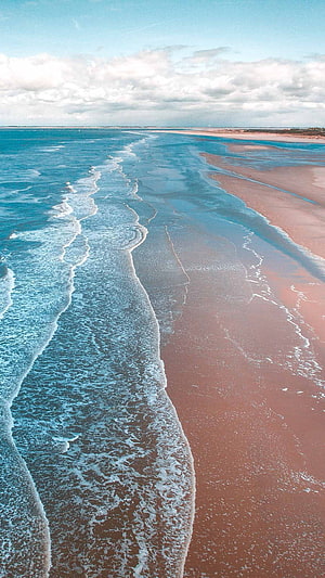 Aerial View of Turquoise Ocean Waves Washing Over Sandy Beach Shoreline HD phone wallpaper