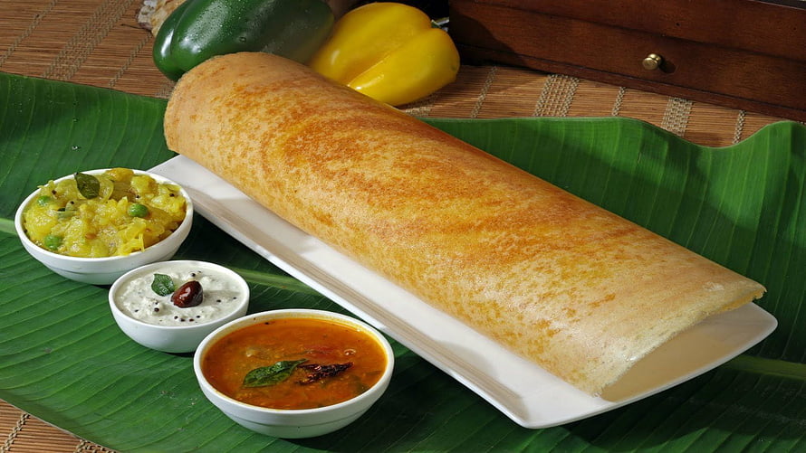 Golden Masala Dosa Served with Sambar, Chutney, and Potato Filling on a Banana Leaf HD wallpaper