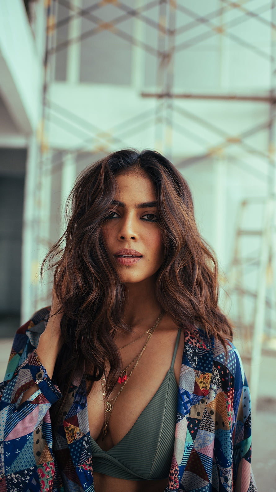 Portrait of a woman with wavy brown hair wearing a colorful patchwork shirt and green top, Malavika mohanan, multilingual actress, model, cleavage HD phone wallpaper