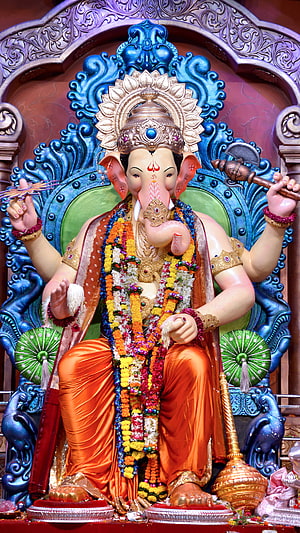 Vibrant Ganesha Statue Adorned with Floral Garlands and Golden Crown HD phone wallpaper