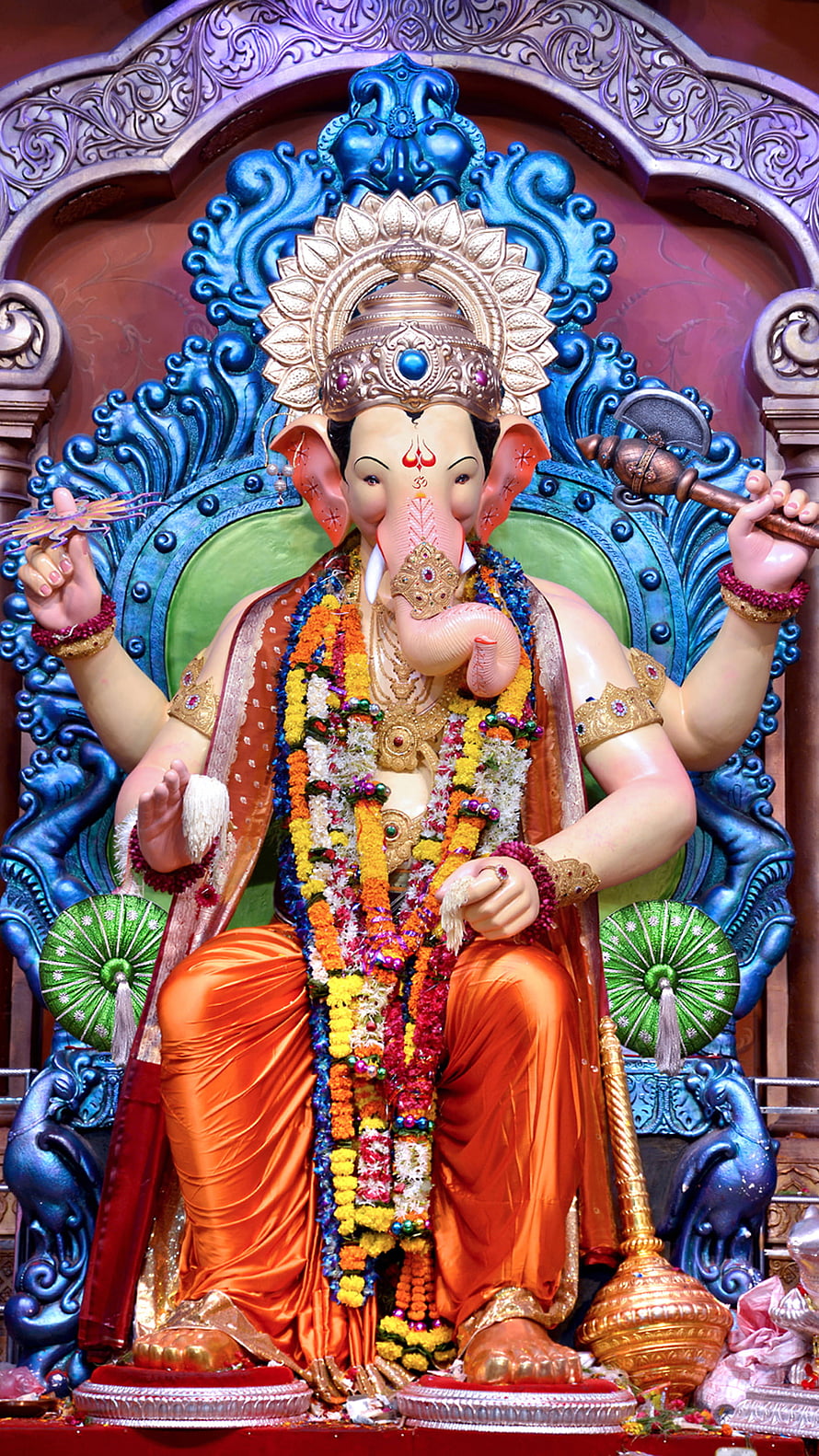 Vibrant Ganesha Statue Adorned with Floral Garlands and Golden Crown HD phone wallpaper