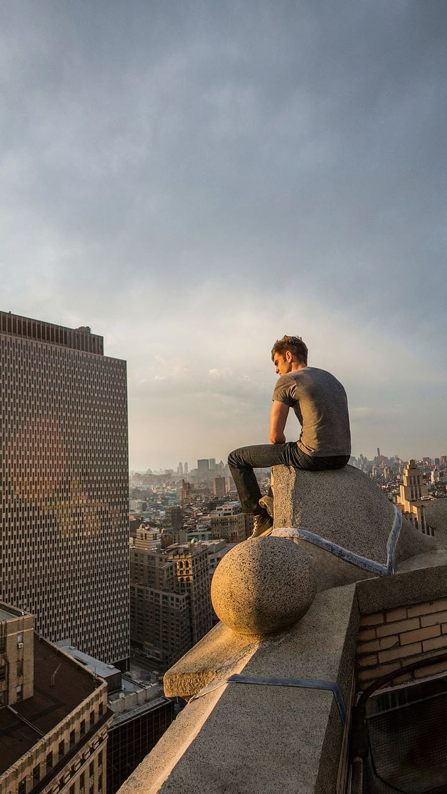 Peter Parker Sitting on a Rooftop Overlooking the New York City Skyline HD phone wallpaper