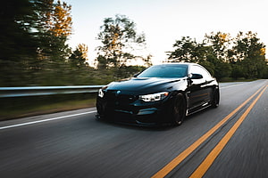 Black BMW M4 Coupe Driving Fast on Scenic Highway at Sunset HD wallpaper